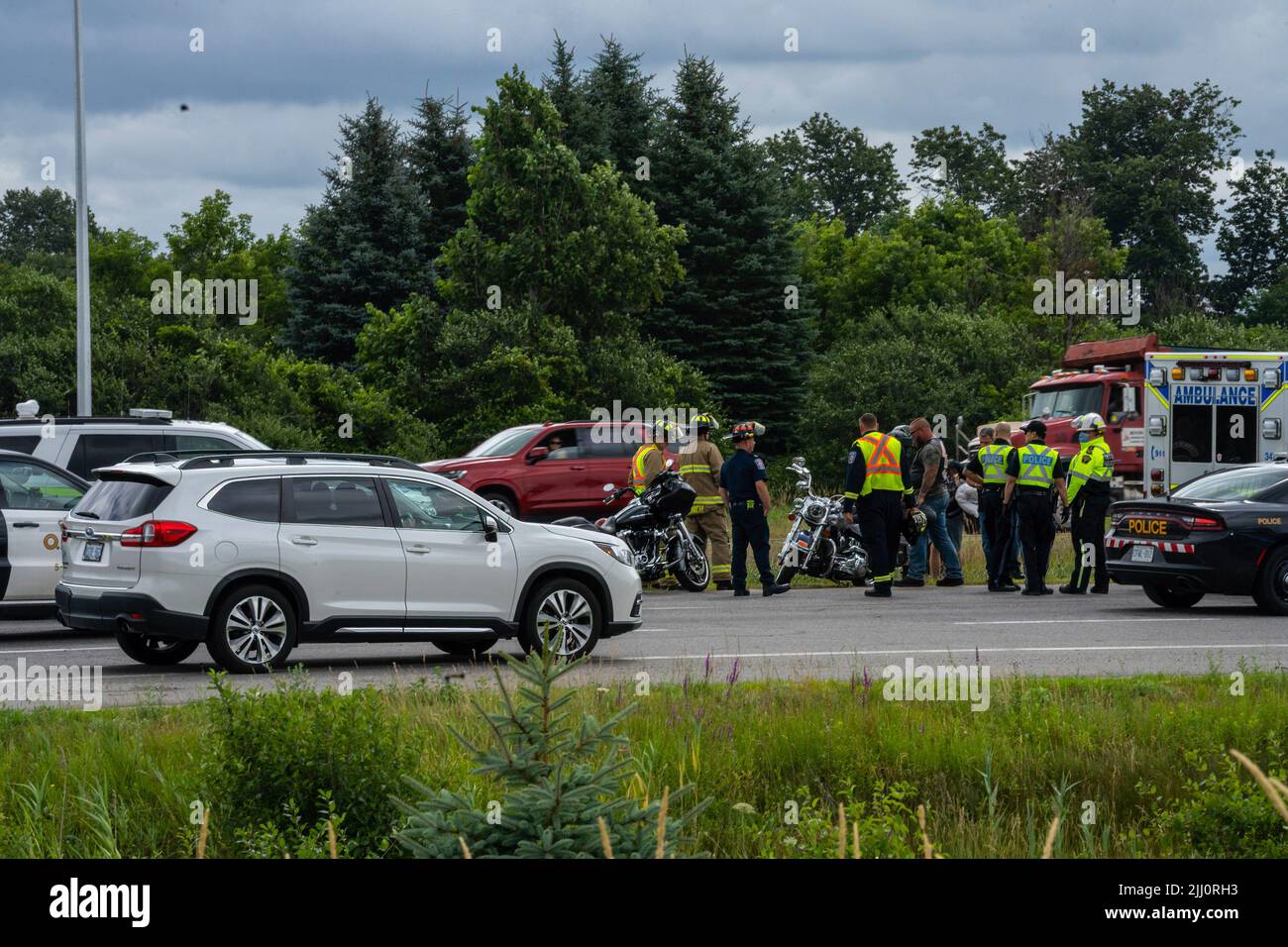 Aurora, Canada. 21st July, 2022. Paramedics, police and firefighters gather around a Hells Angel member who had fallen. Hundreds of Hells Angels members rolled through York Region towards Toronto for a memorial procession. The procession is in honor of a fallen member of the outlaw Hells Angels Motorcycle Club. Credit: SOPA Images Limited/Alamy Live News Stock Photo