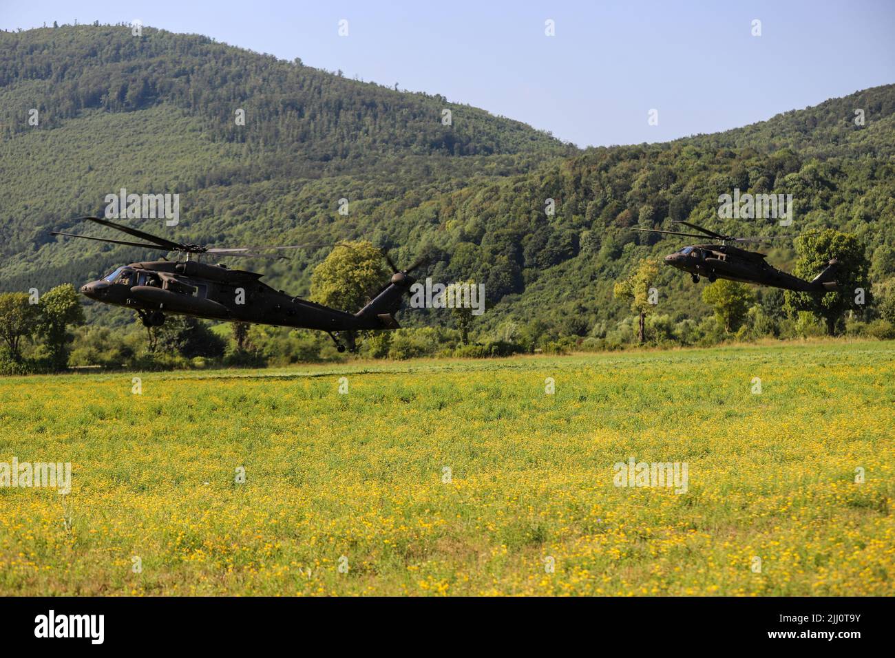 U.S. Army pilots from the 12th Combat Aviation Brigade conduct tactical combat maneuvers with UH-60 Black Hawks at Kasarna Manjaca, Dobrnja, Bosnia and Herzegovina on July 17, 2022. Guard members assigned to the State Medical Detachment and 1-169th Aviation Regiment, Maryland Army National Guard, trained alongside active duty Soldiers from the 1st Squadron, 91st Cavalry Regiment, 173rd Airborne Brigade, 12th Combat Aviation Brigade, and the Armed Forces of Bosnia and Herzegovina soldiers in tactics, aviation, medical, and non-commissioned officer development. The Maryland National Guard will c Stock Photo