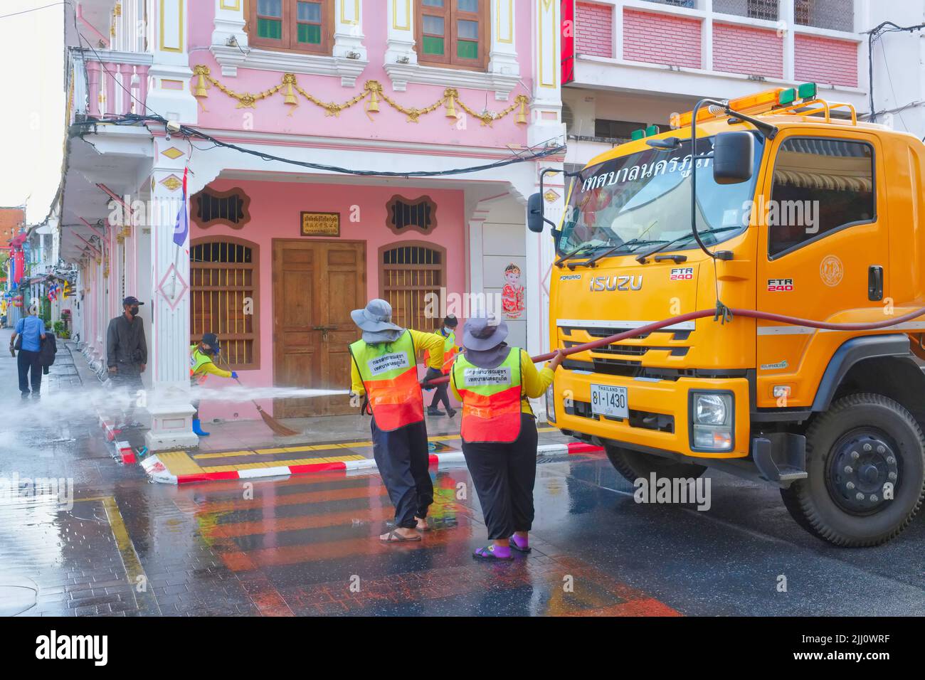 Early morning, municipal workers clean Thalang Road in the Old Town area of Phuket Town, Thailand, its Sino-Portuguese houses a tourist attraction Stock Photo