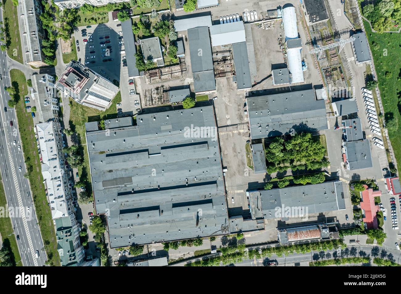aerial top view of roofs of factory buildings and warehouses at industrial district. sunny summer day. Stock Photo