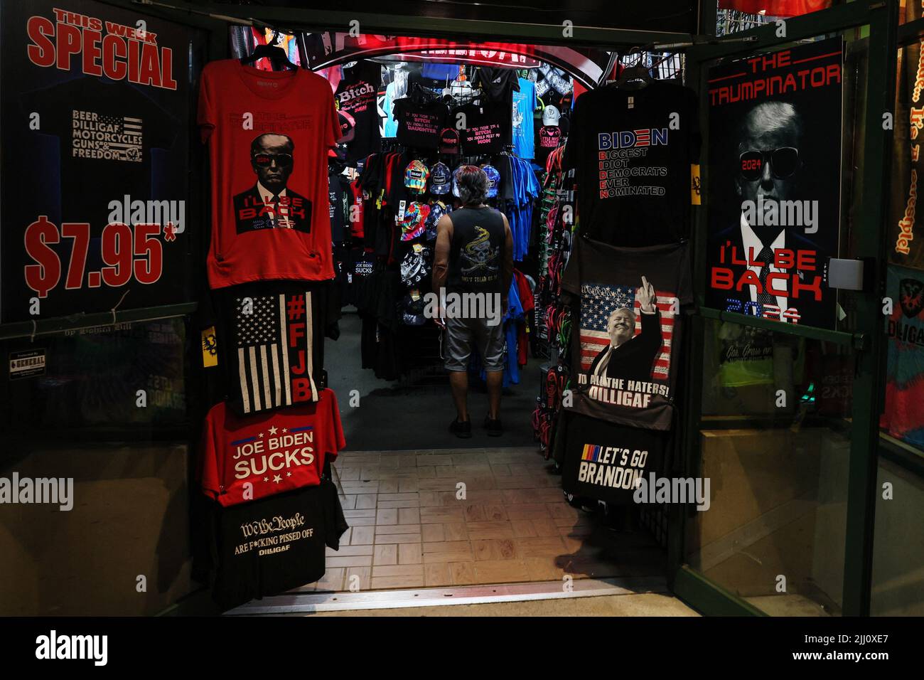 A man looks at merchandise inside a shop specializing in tee shirts and clothing that intends on making a statement along the main strip in Lake George, New York, U.S., July 21, 2022. REUTERS/Shannon Stapleton Stock Photo