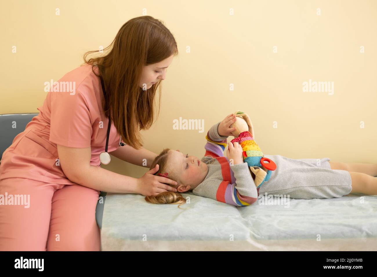 Pediatrician woman giving head massage to little girl in hospital Stock  Photo - Alamy