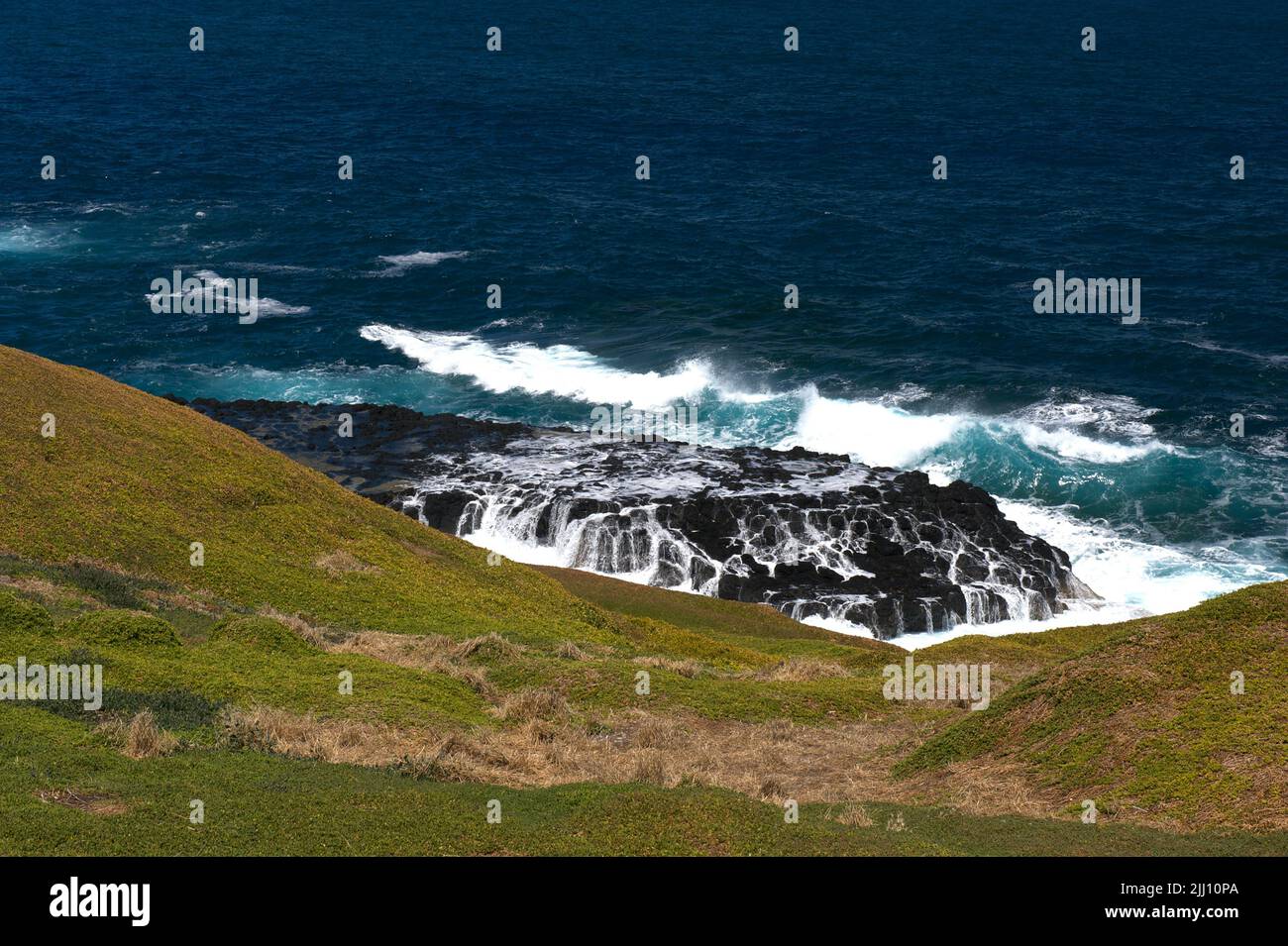 A view of the aftermath of breaking waves on the rocks near The Nobbies on Phillip Island, Victoria, Australia. Bass Strait is famous for rough seas. Stock Photo