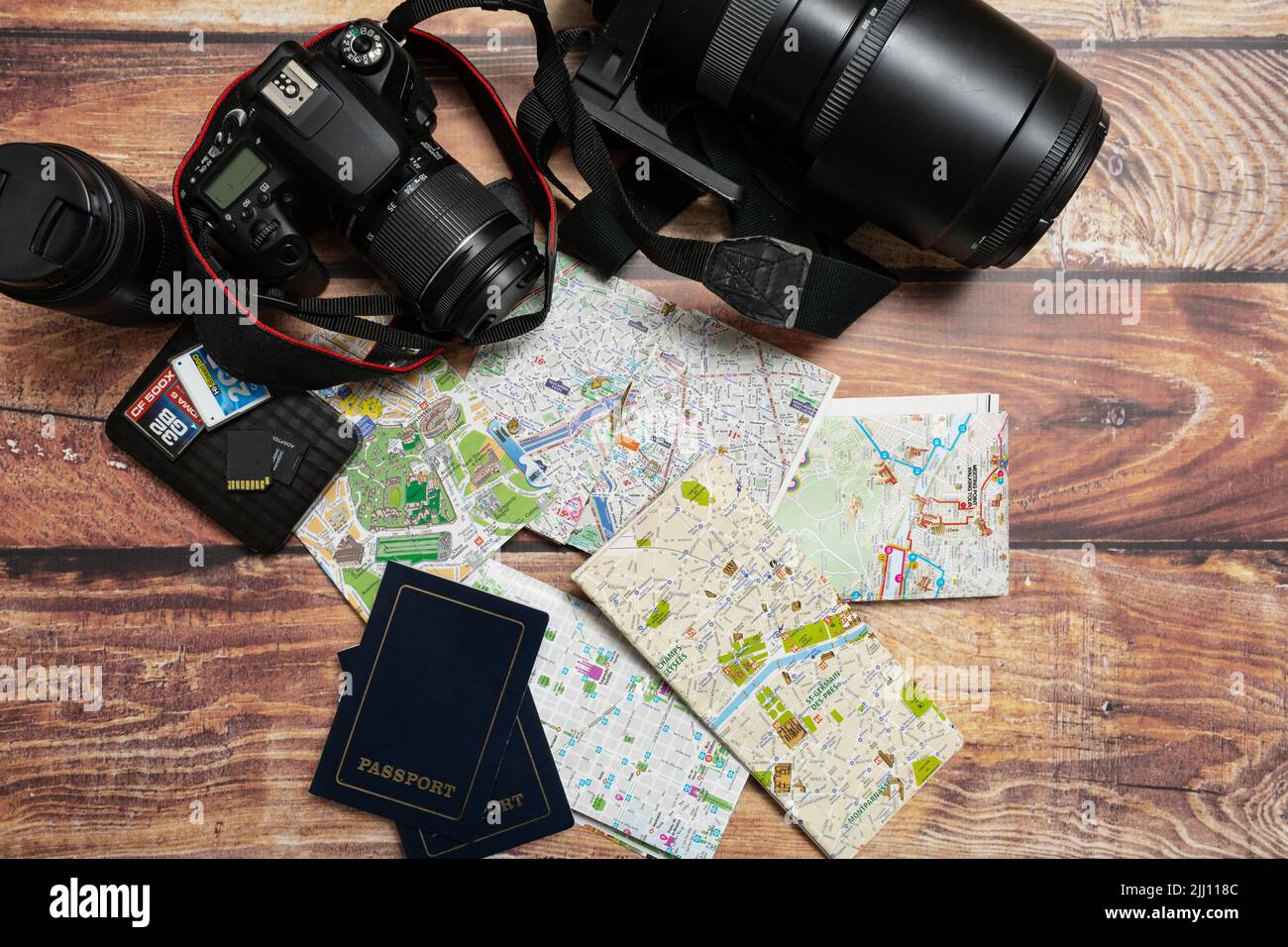 A City maps next to cameras and passport on a wooden table. Concept of vacations, travels, travelers, Copy space. Stock Photo