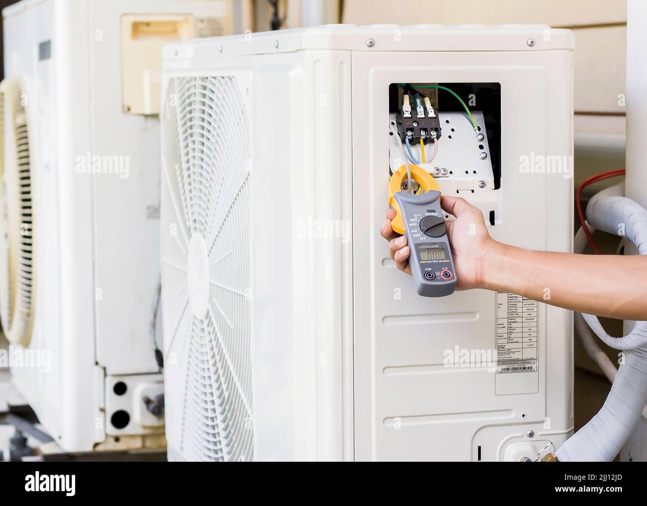 Air conditioner repairman using electricity meter to check air