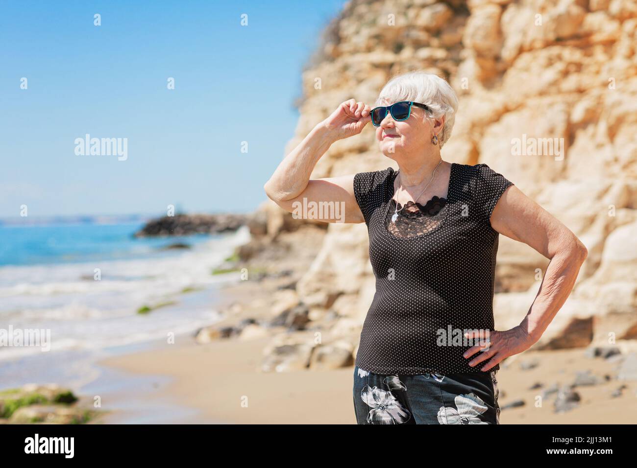 Senior woman of retirement age standing on the shore Stock Photo
