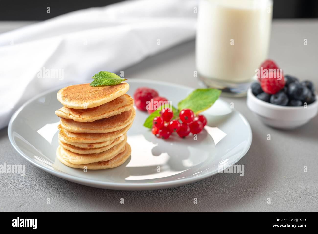 Mini pancakes with blueberries and raspberries. American breakfast on a ...