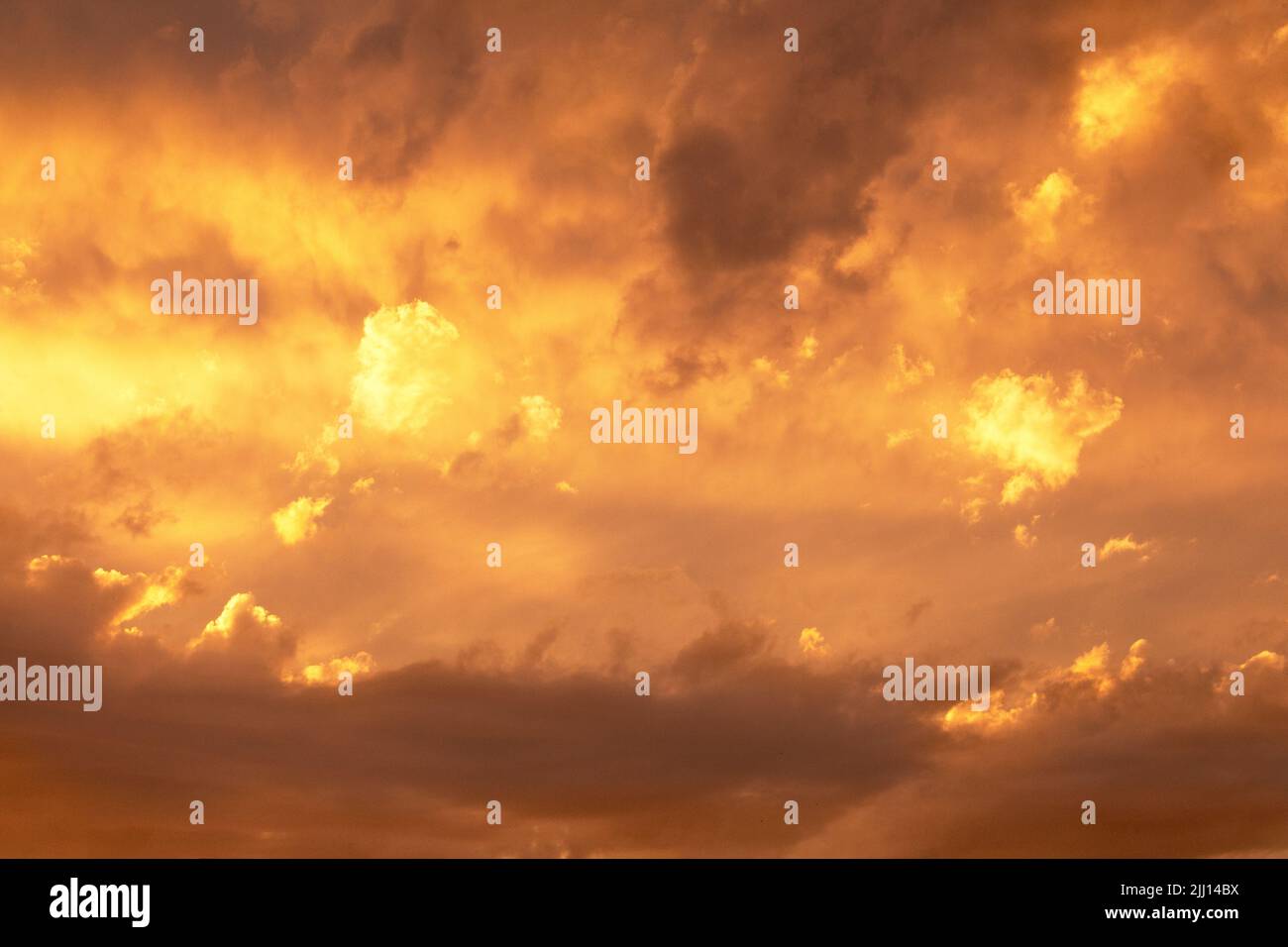 Sunset or dawn sky, yellow clouds with rays and hidden sun. Heaven high/ Copy space Stock Photo