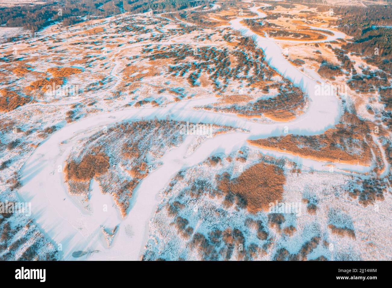 Aerial view forest woods and river landscape in winter day. Bird's eye view of small island and curved river landscape in winter day. Top view of Stock Photo