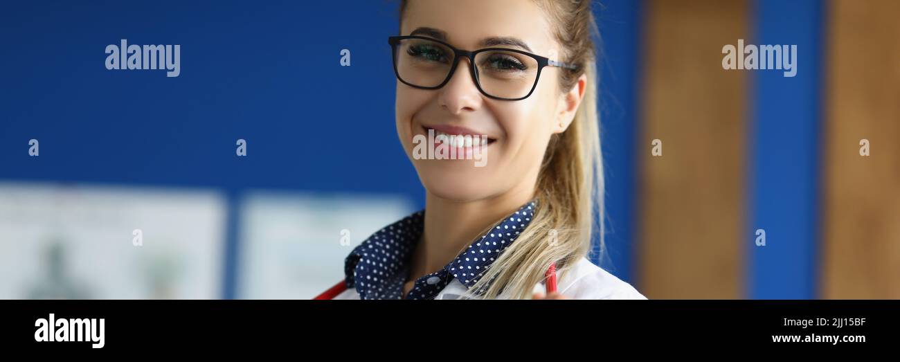 Cheerful doctor in uniform wear stethoscope tool posing in clinic office Stock Photo