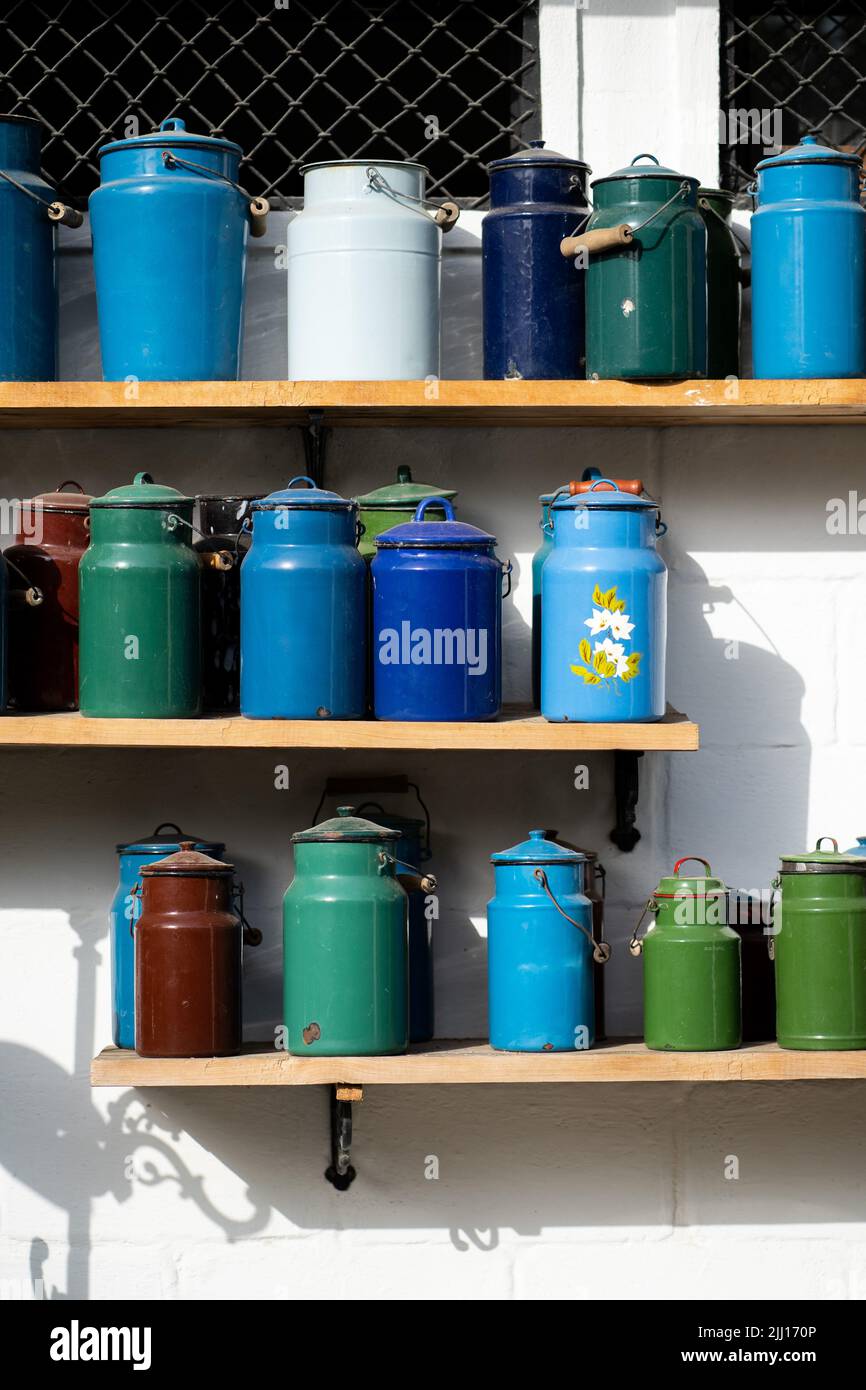 Many colourful vintage cans for milk standing at the shelves Stock Photo
