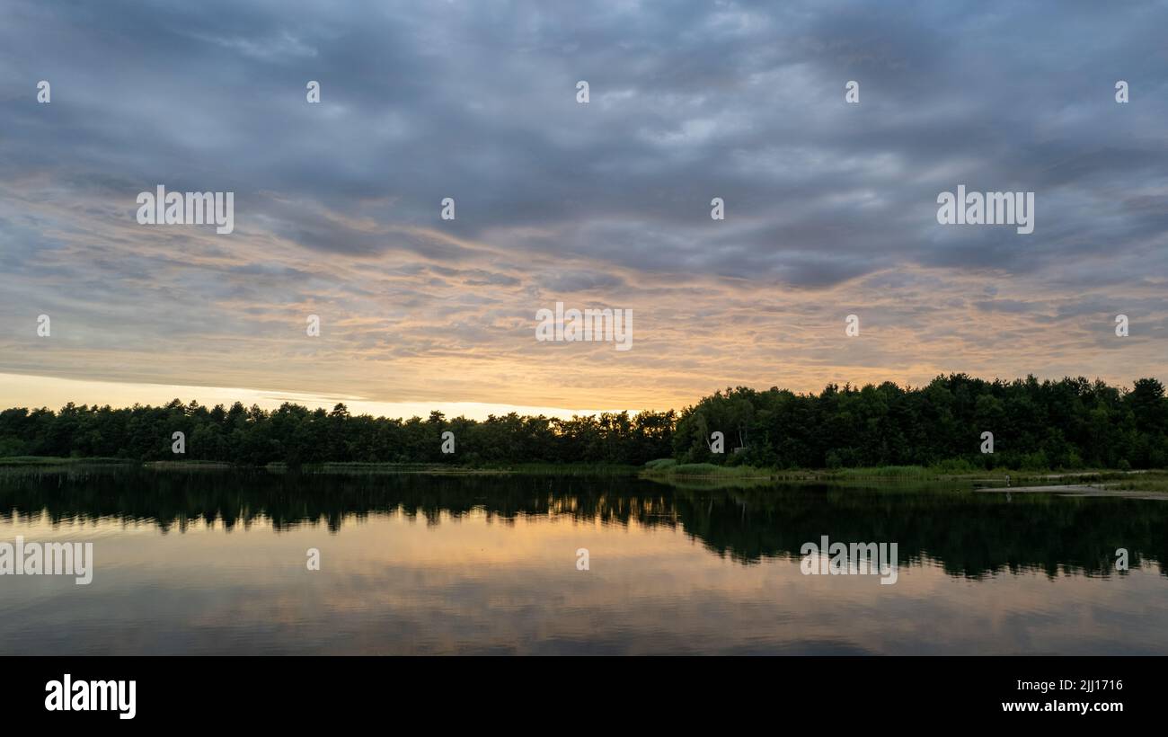 Aerial view, shot by a drone of a sunset at coast of the lake. Nature landscape. Nature in northern Europe. reflection, blue sky and yellow sunlight. landscape during sunset. High quality photo Stock Photo