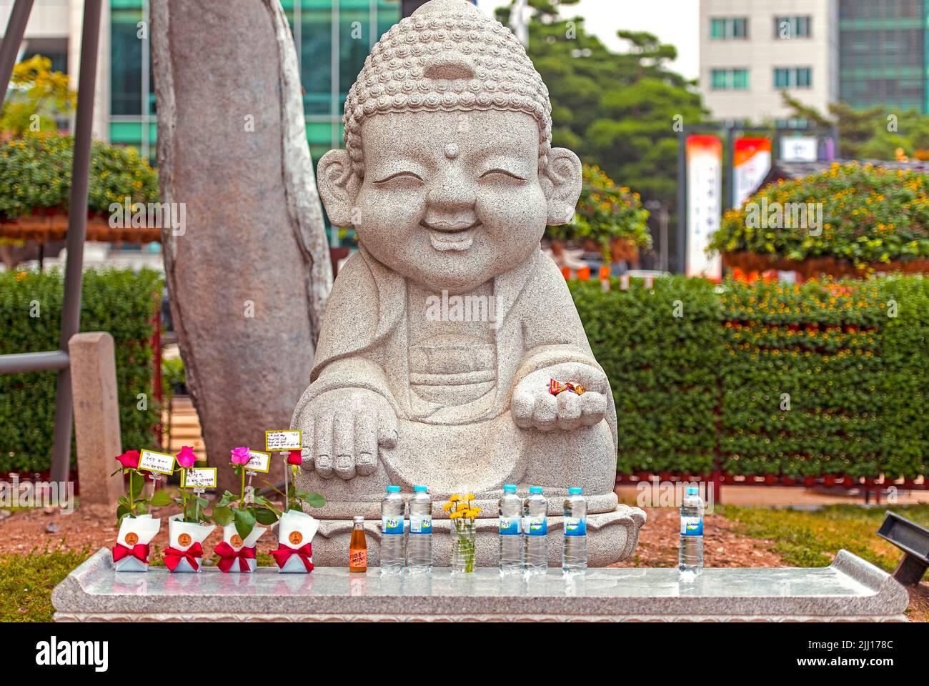 SEOUL - OCT 01: Smiling stone buddha statue with gifts  at the Jogyesa temple in Seoul, October 01. 2016 in South Korea Stock Photo