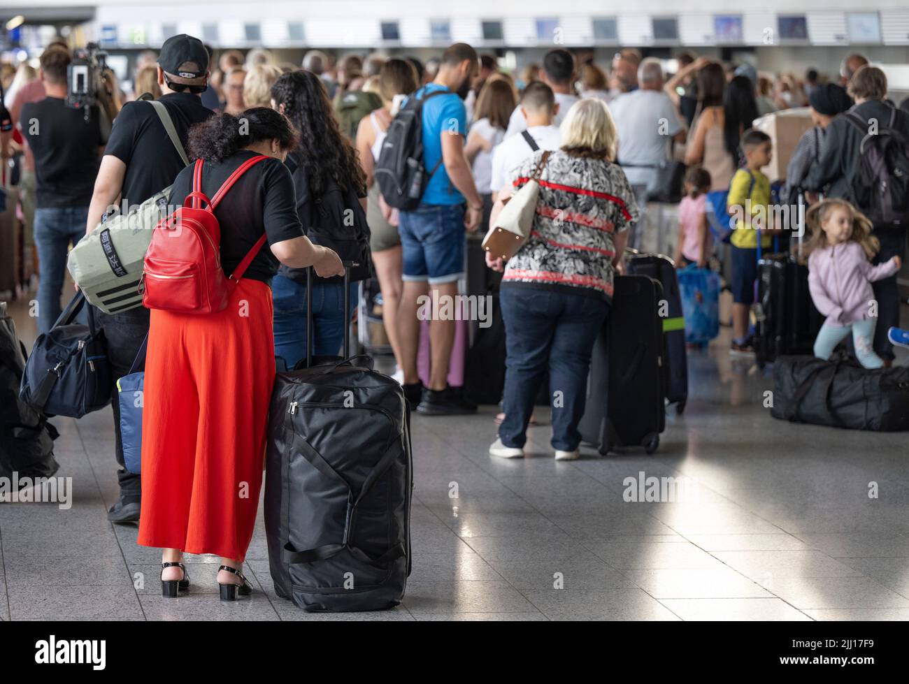 22 July 2022, Hessen, Frankfurt/Main: Thousands of passengers are waiting to check in at the airport's check-in counters. In view of the start of the vacations in several German states, airport operator Fraport is expecting a record rush. Around 200,000 passengers per day are expected on each of the weekends from July 22 to 24, 2022. Photo: Boris Roessler/dpa Stock Photo