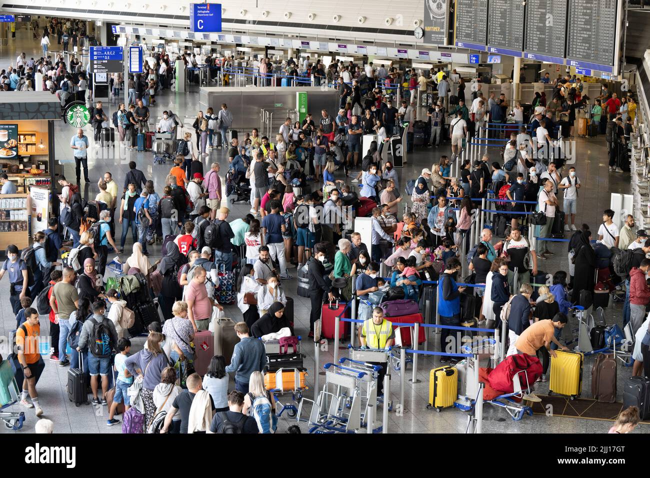 22 July 2022, Hessen, Frankfurt/Main: Thousands of passengers are waiting to check in at the airport's check-in counters. In view of the start of the vacations in several German states, airport operator Fraport is expecting a record rush. Around 200,000 passengers per day are expected on each of the weekends from July 22 to 24, 2022. Photo: Boris Roessler/dpa Stock Photo