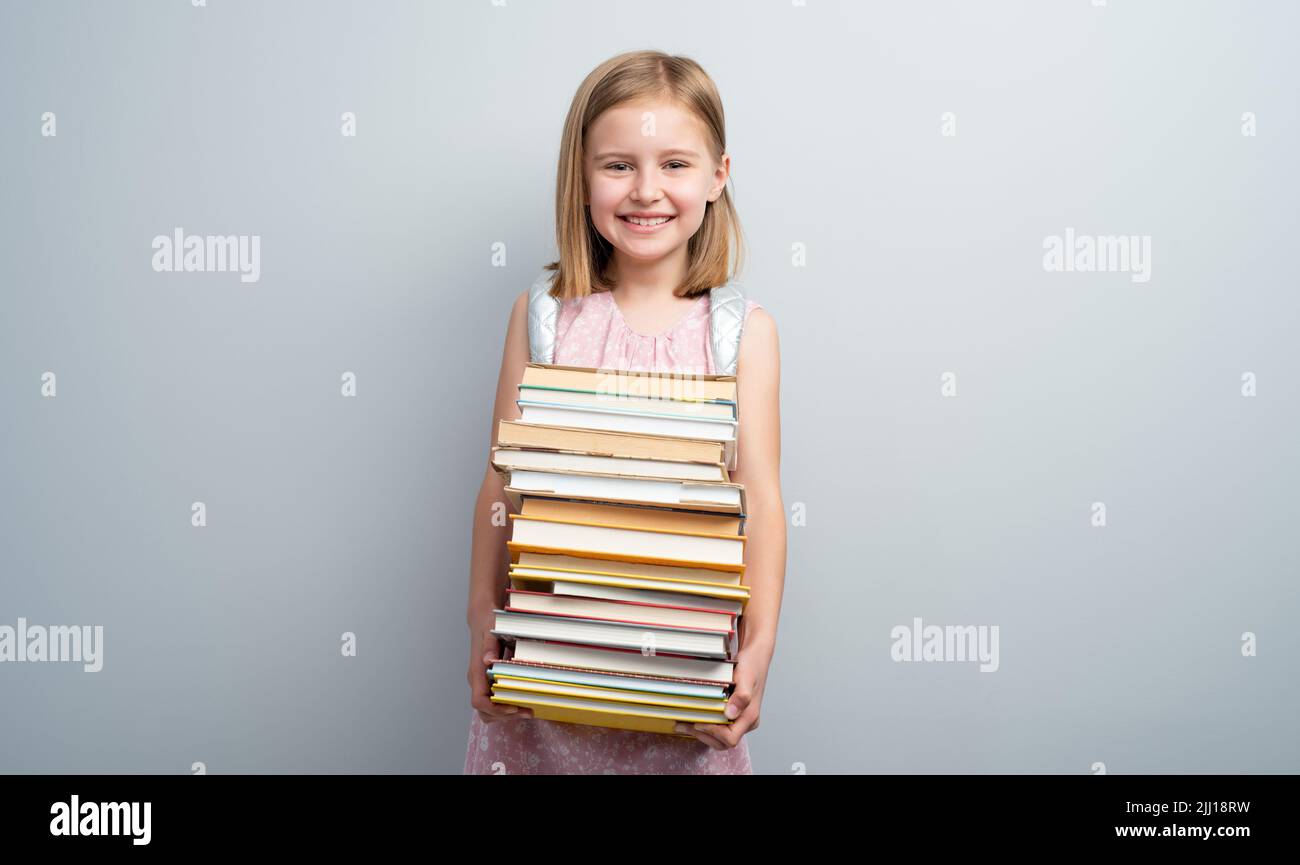 Little girl with backpack and textbooks Stock Photo - Alamy