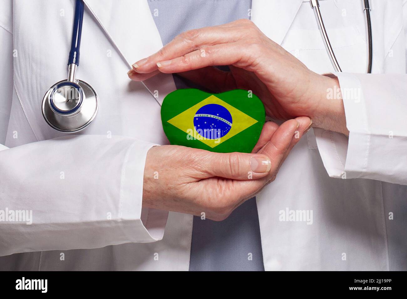 Brazilian doctor holding heart with flag of Brazil background