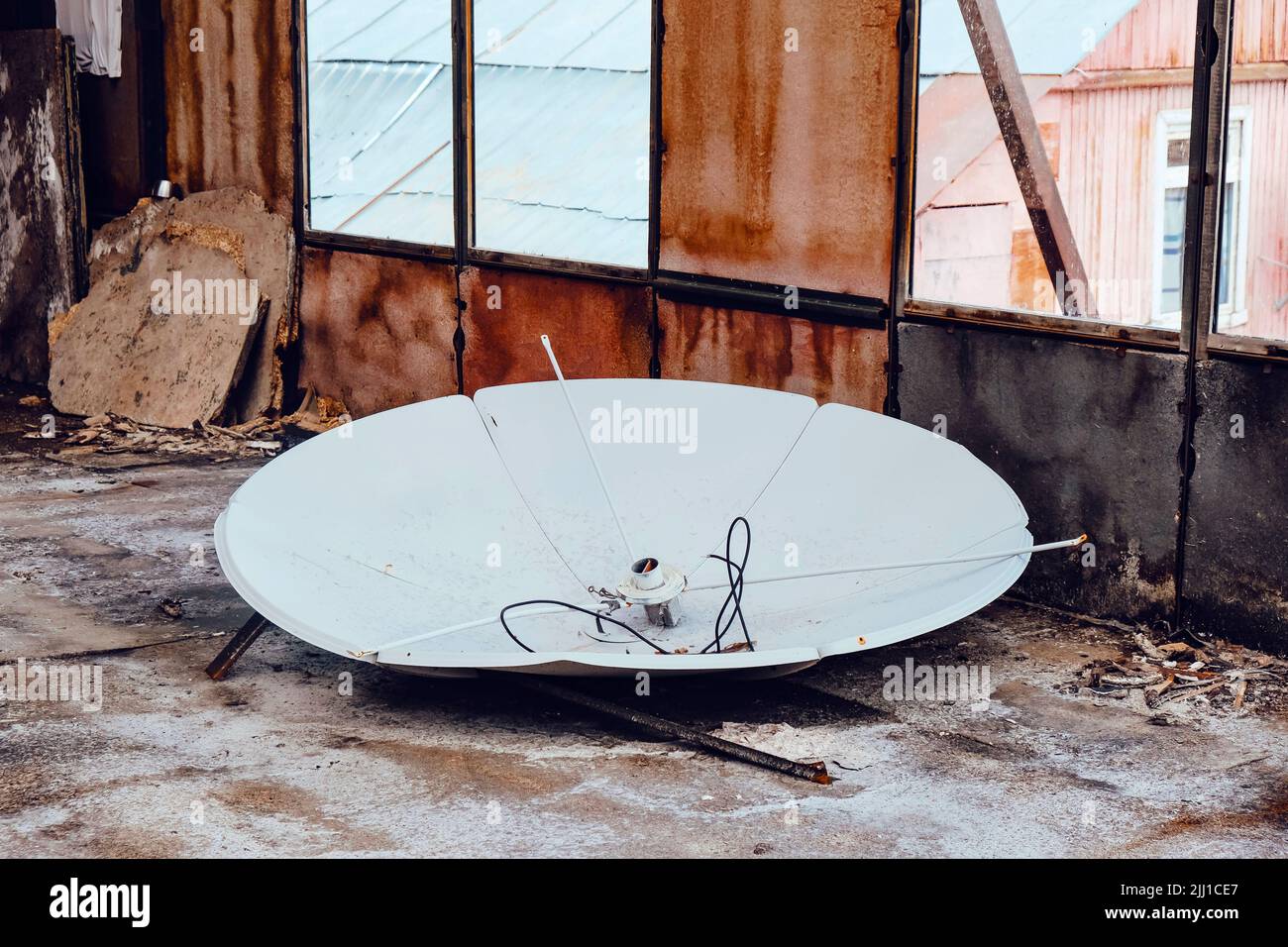 Old white satellite dish in an abandoned warehouse Stock Photo Alamy