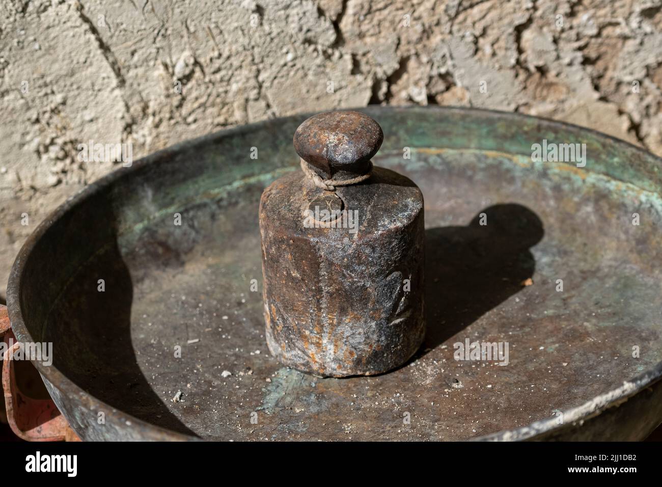https://c8.alamy.com/comp/2JJ1DB2/selective-focus-shot-of-iron-kilogram-scale-placed-in-old-metal-container-2JJ1DB2.jpg