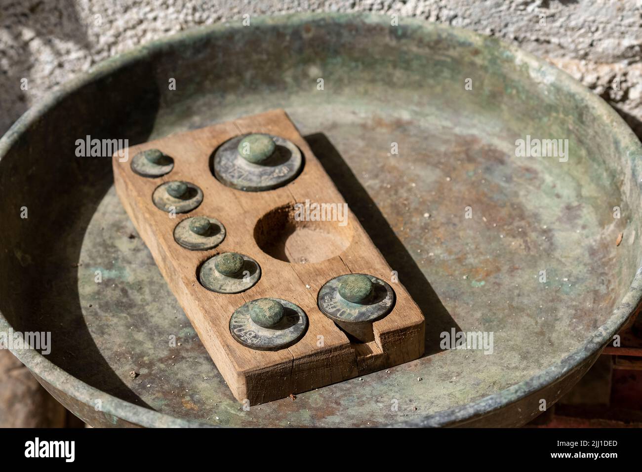 Selective focus shot of kilograms of iron used for weighing in a scale, in wooden boxes. Stock Photo