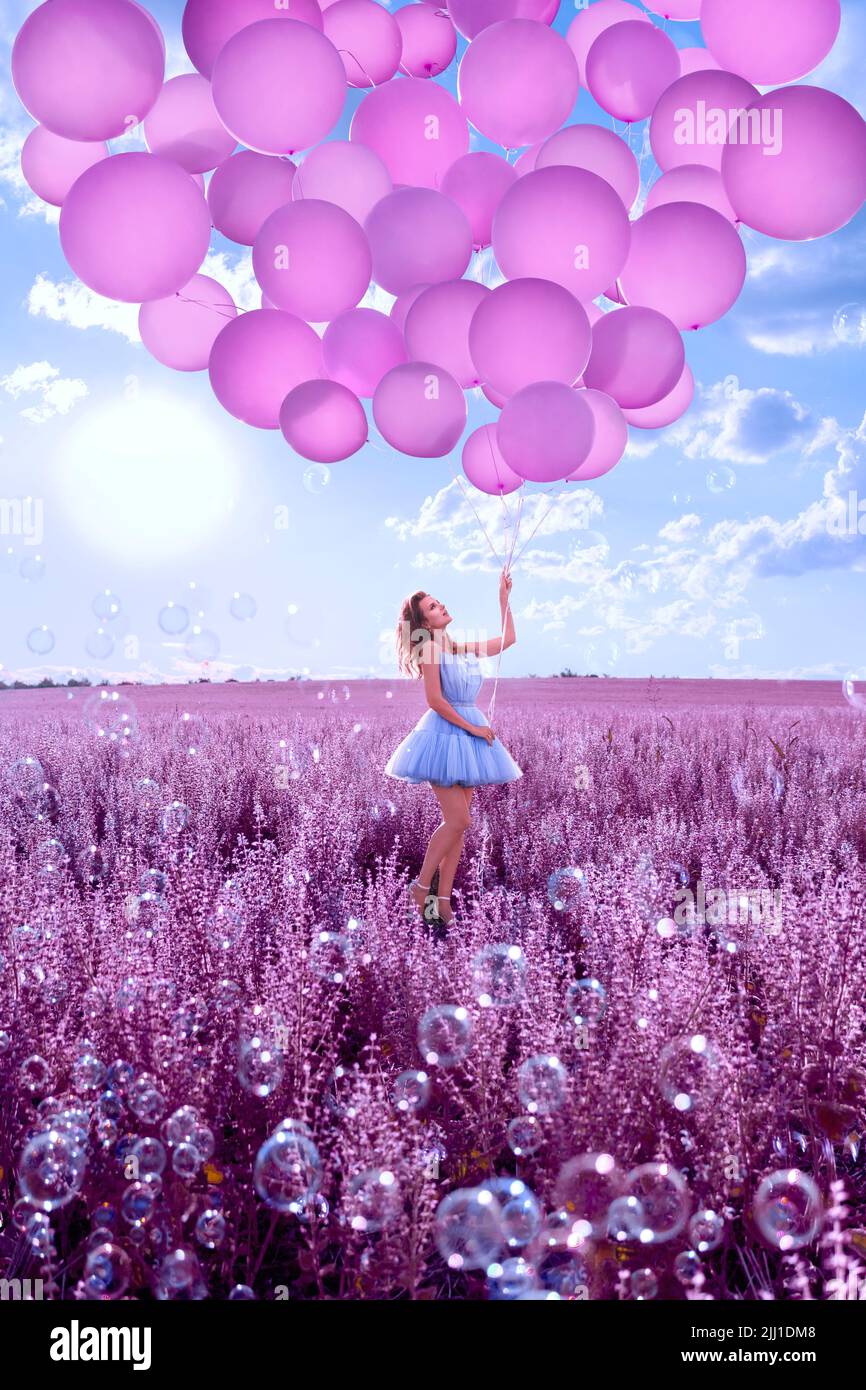 Beautiful woman with pink balloons in lavender field Stock Photo