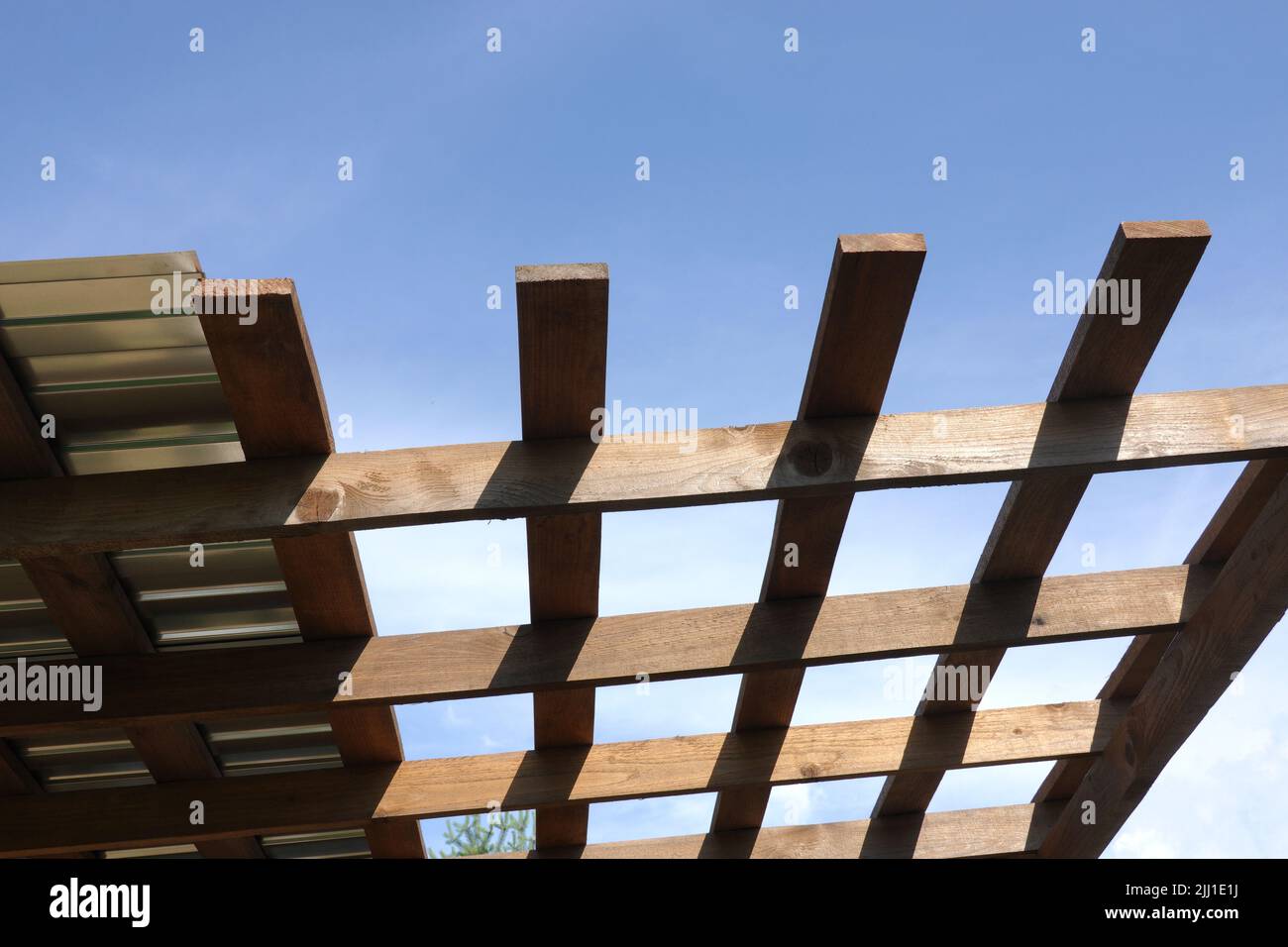 Metal roof mounting on brown wooden gazebo crate on a sunny summer day bottom up view outdoors Stock Photo