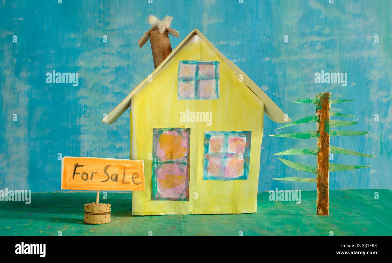 Cute model home with for sale  sign. Real estate,buying house,home loan concept.Free copy space Stock Photo