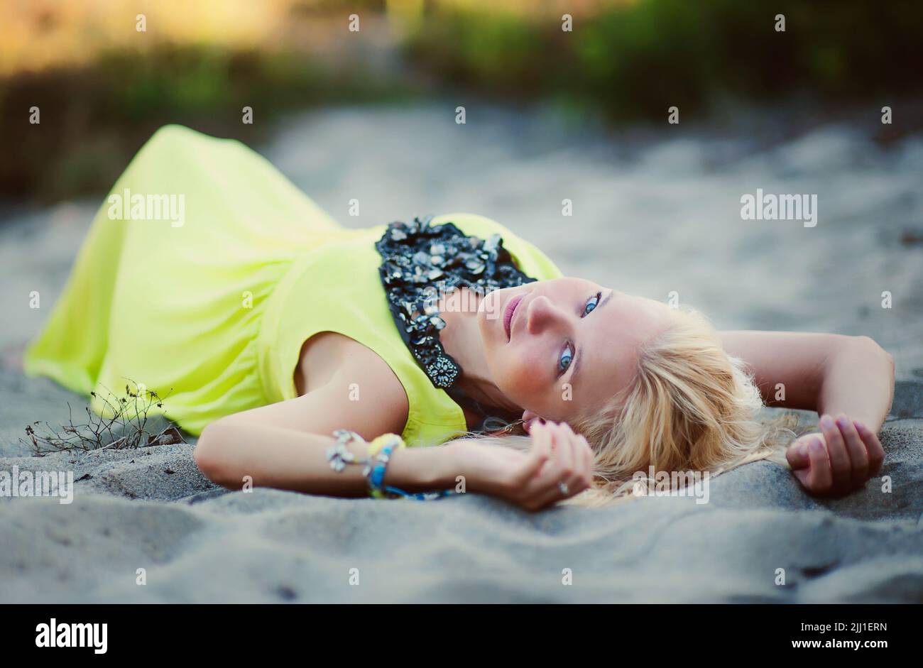 Beautiful girl lying on the sand on a background of nature Stock Photo