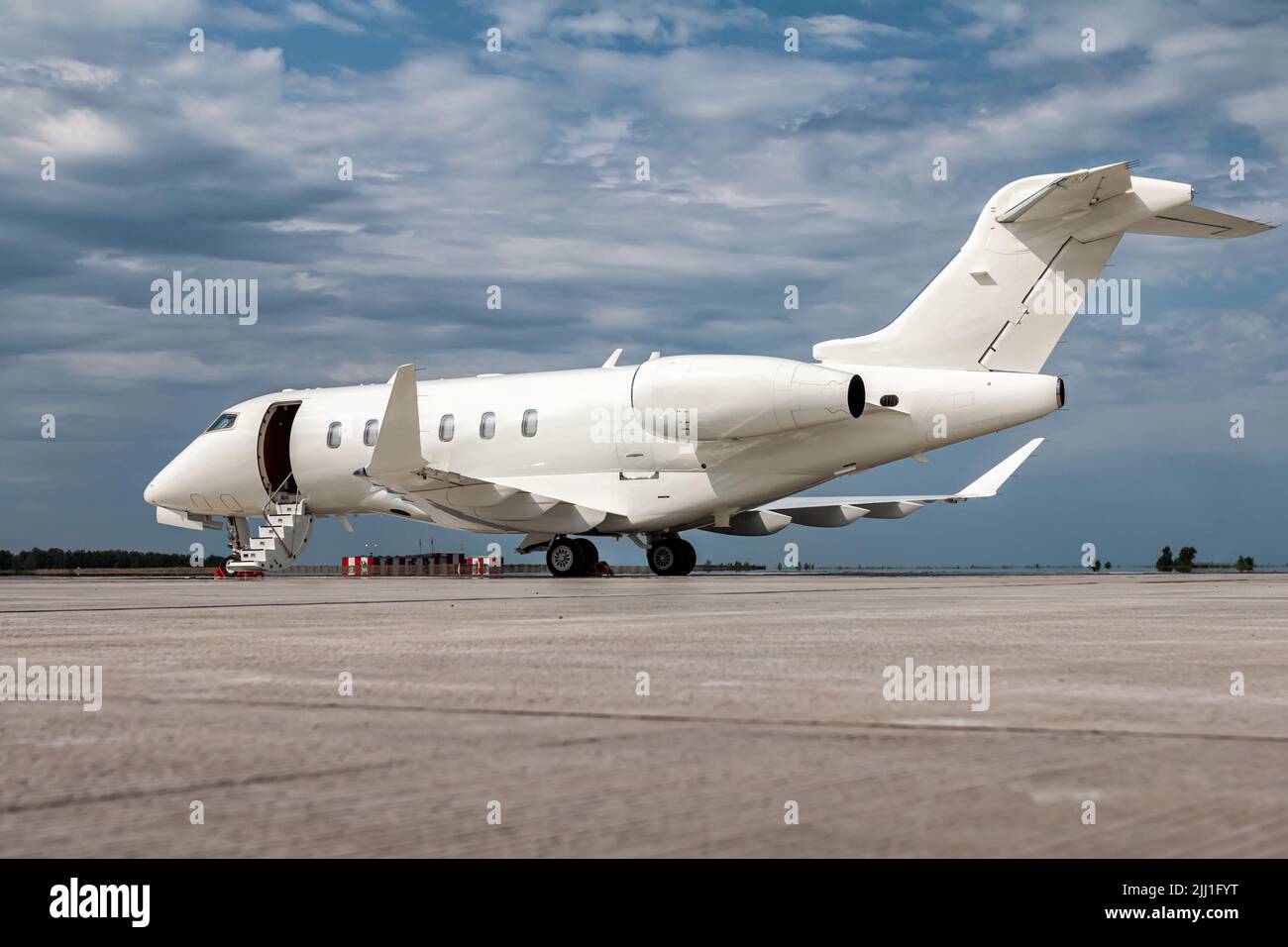 Modern white private jet with an opened gangway door at the airport apron Stock Photo
