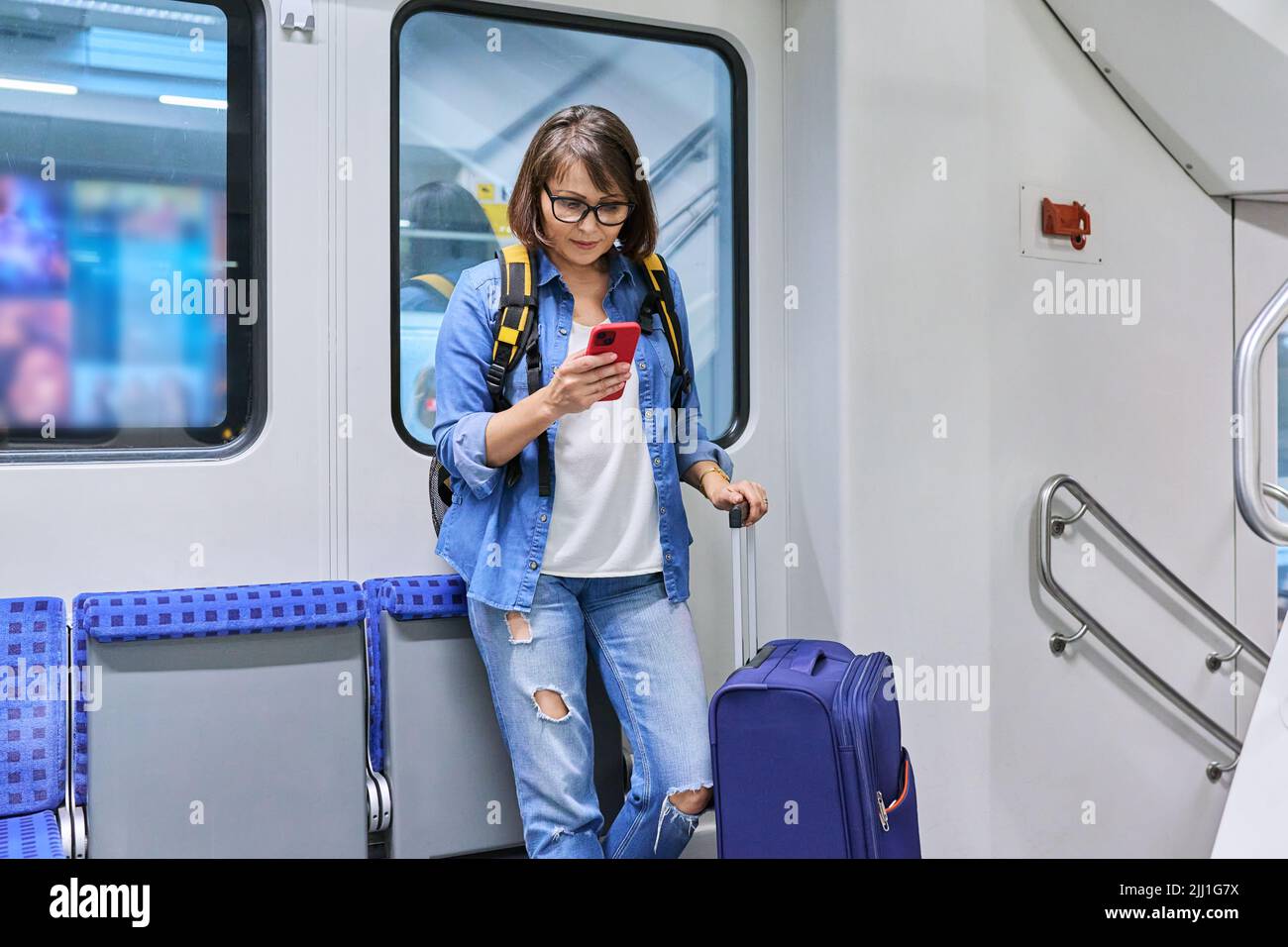 Woman passenger with suitcase backpack standing inside the car