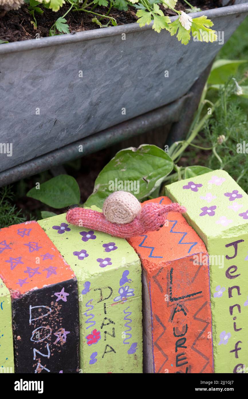 Walton Charity Community Allotment yarn bomb display at RHS Hampton Court Palace Flower show 2022. Knitted snail amongst the allotment Stock Photo