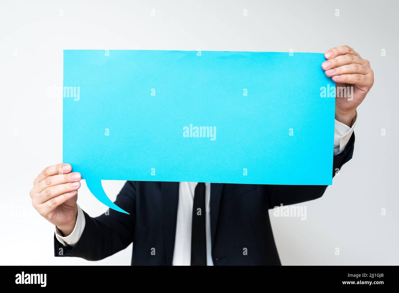 Businessman Holding Speech Bubble With Important Messages. Man In Suit Presenting Crutial Informations On Dialogue Balloon. Gentleman Showing Recent Stock Photo