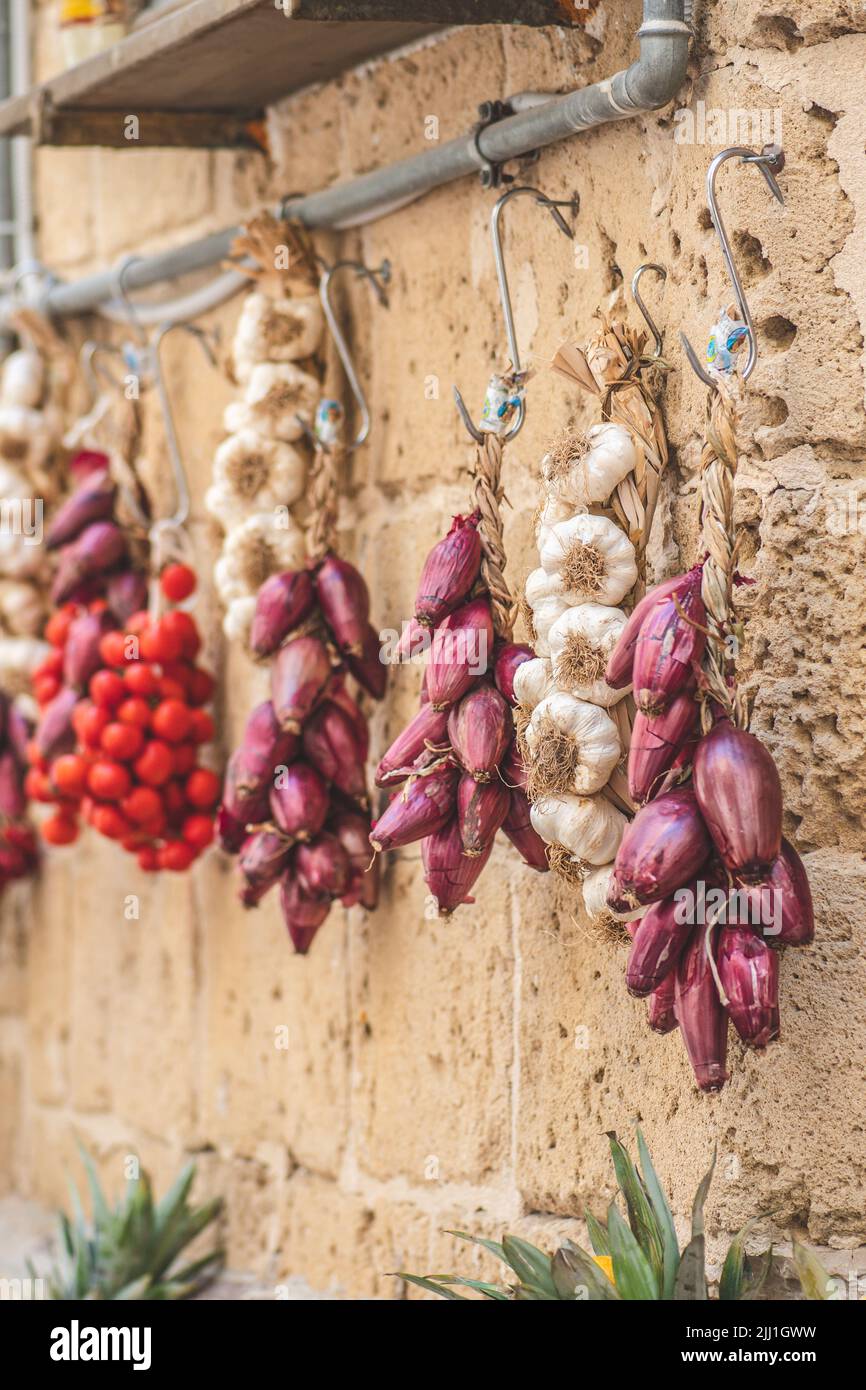 Bunch of and fresh white garlic, red onion and cherry tomatoes hanging