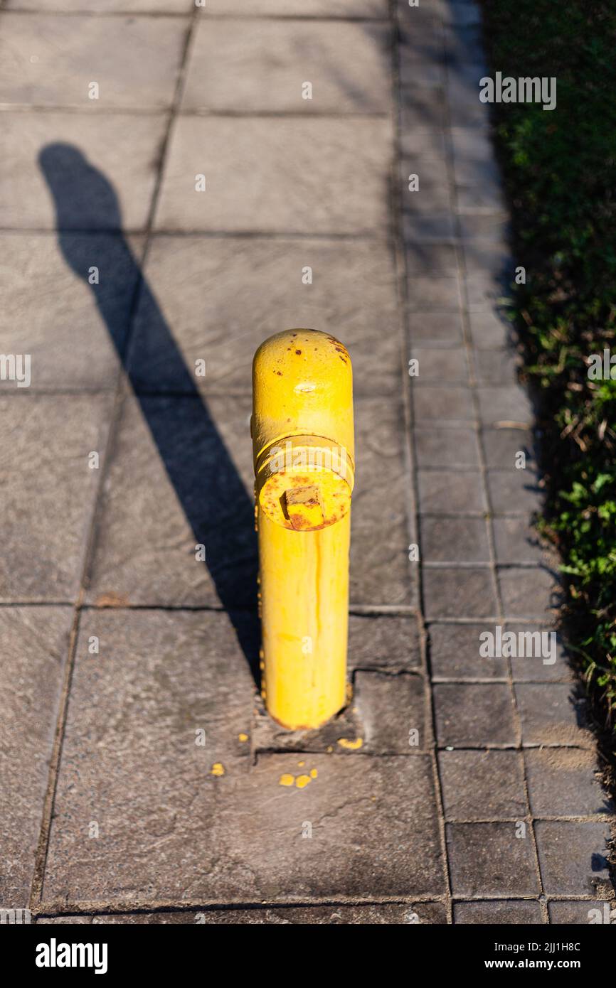 A yellow fire hydrant on a sidewalk, Durban South Africa. Stock Photo