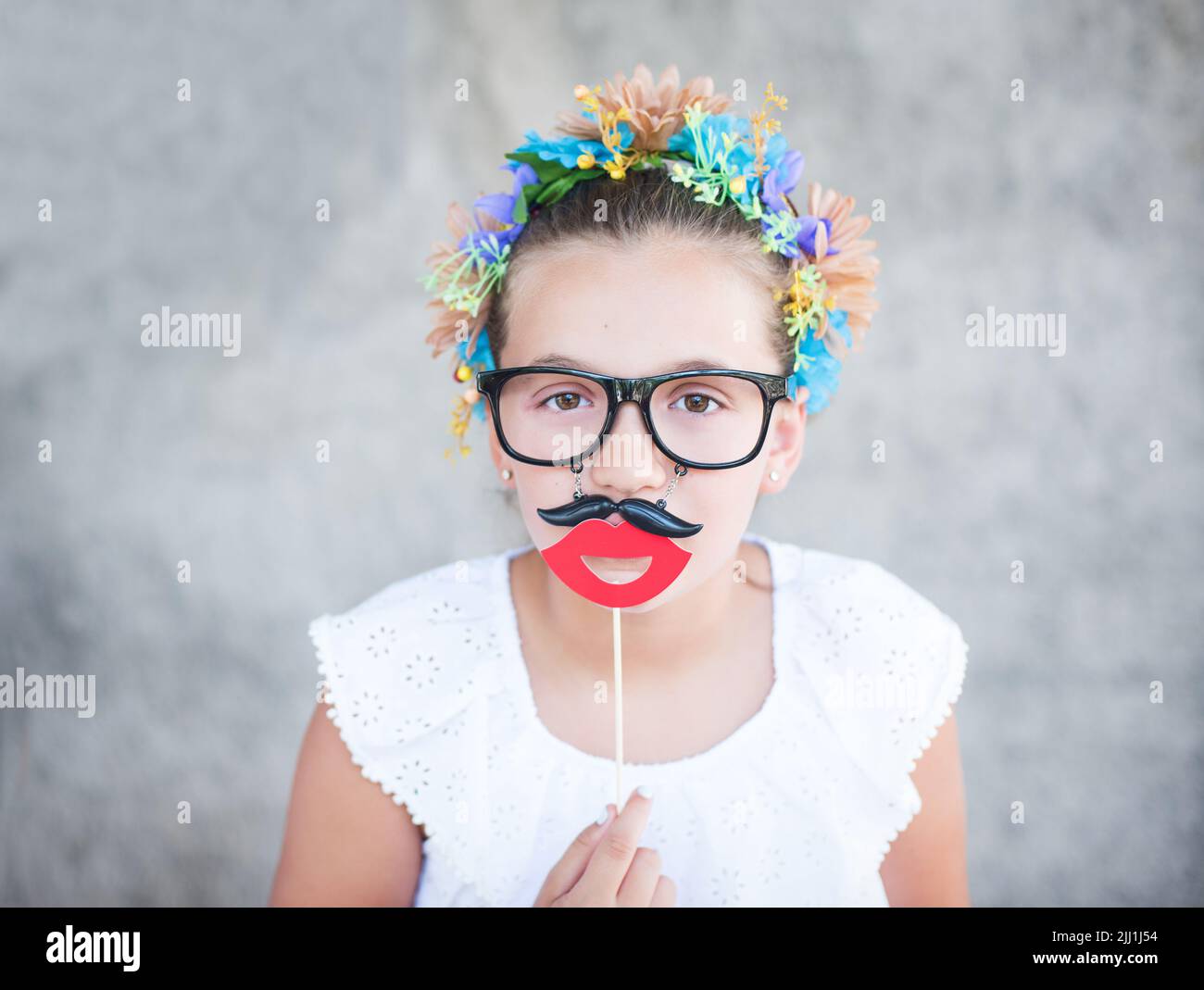 Beautiful girl with Santa beard and mustache prop or mask. Stock Photo