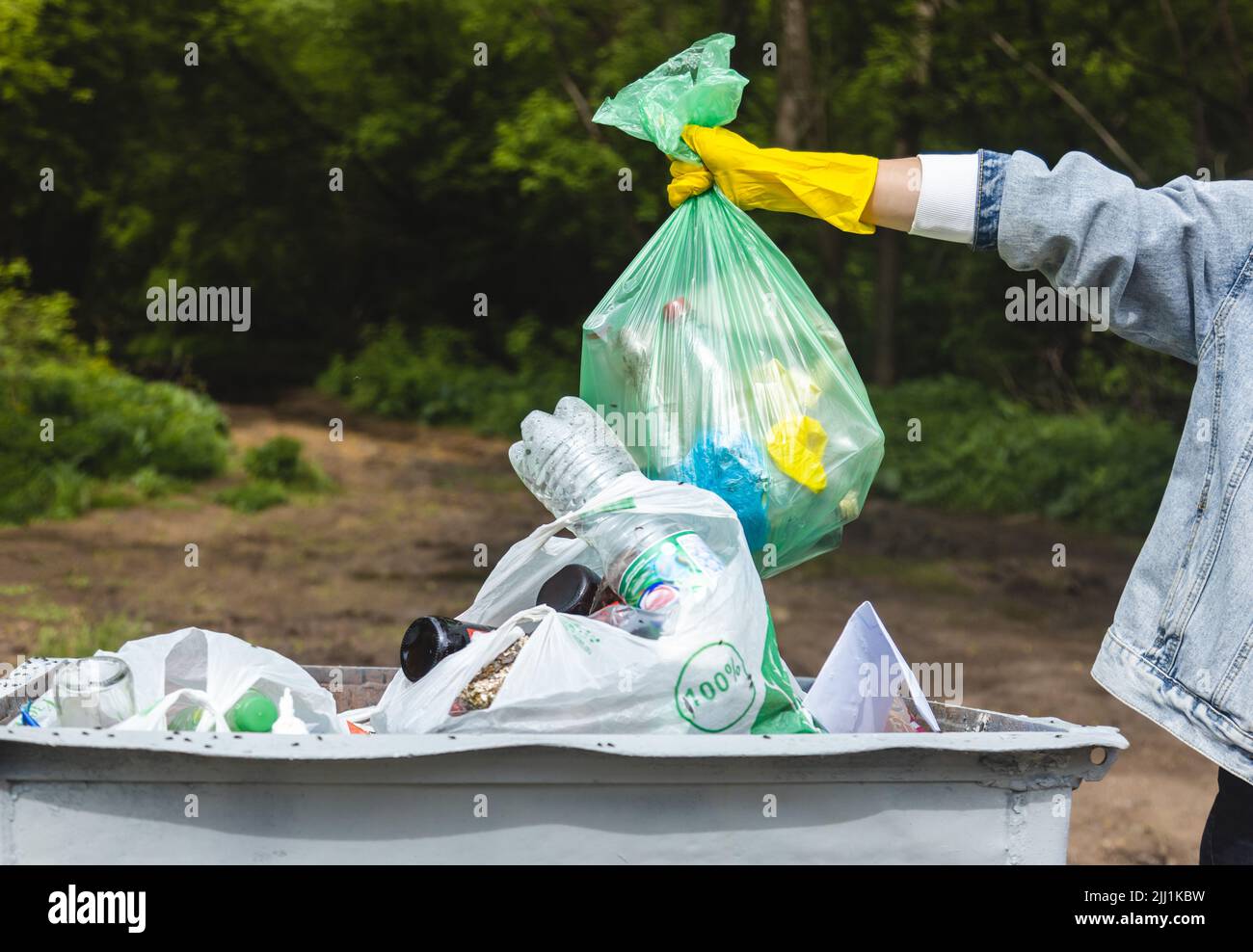 Throwing garbage into a trash can. Closeup of a hand holding a garbage