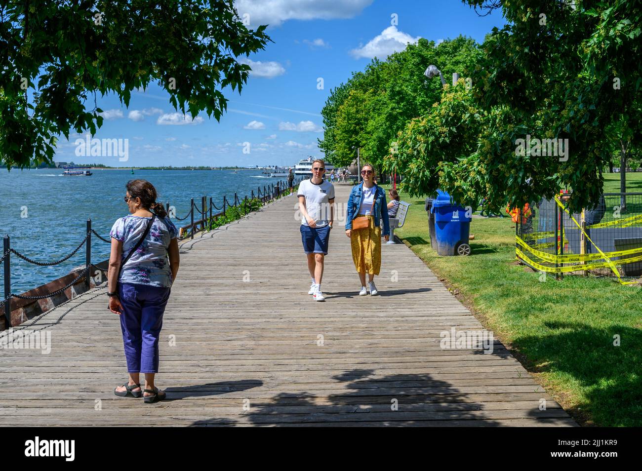 People walking leisurely along the boarswalk at Harbour Square Park on the Toronto harbourfront, Ontario, Canada. Stock Photo