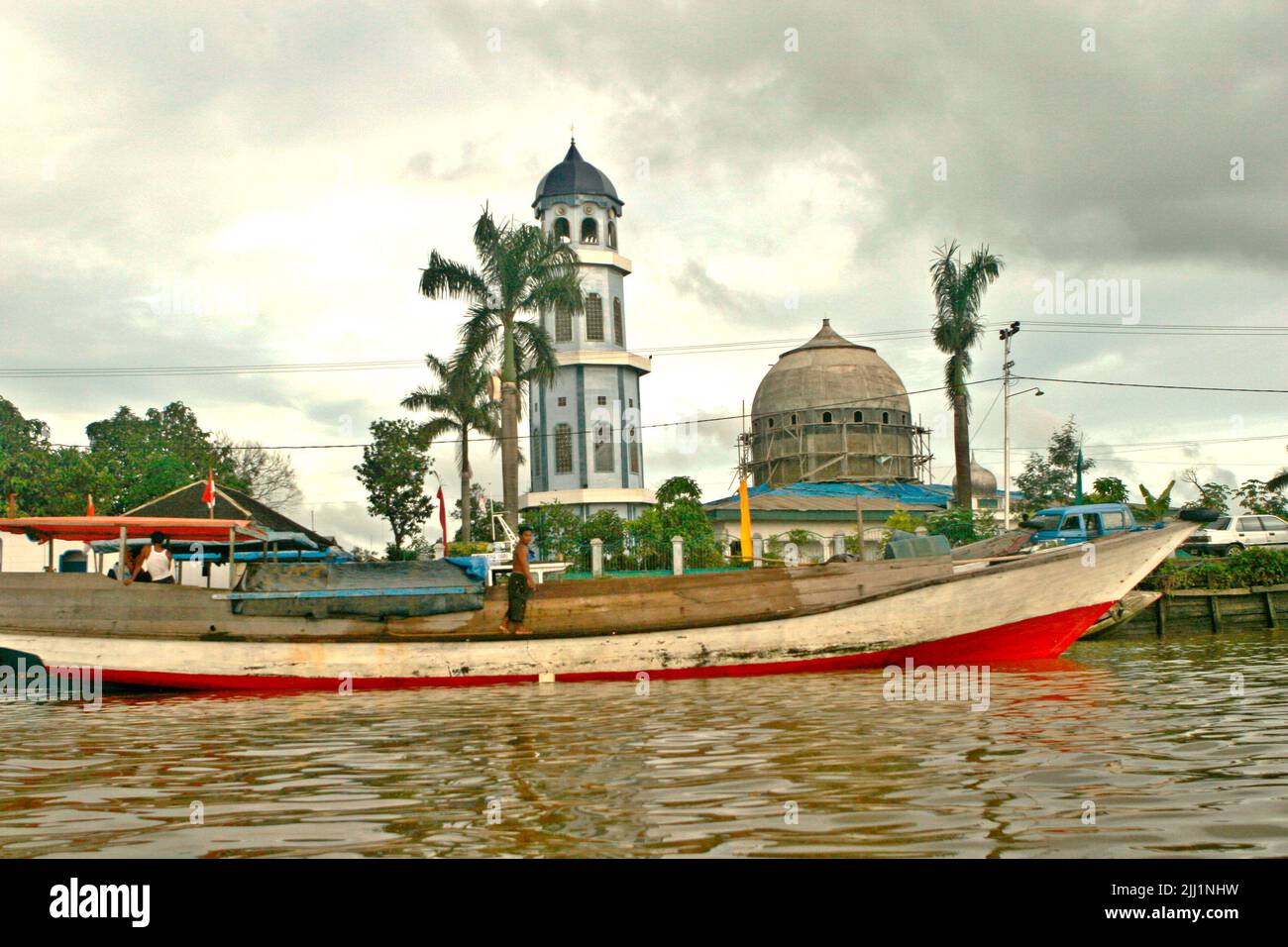 A mosque is photographed in a foreground of a boat, seen from Segah river in Tanjung Redeb, Berau, East Kalimantan, Indonesia. Stock Photo