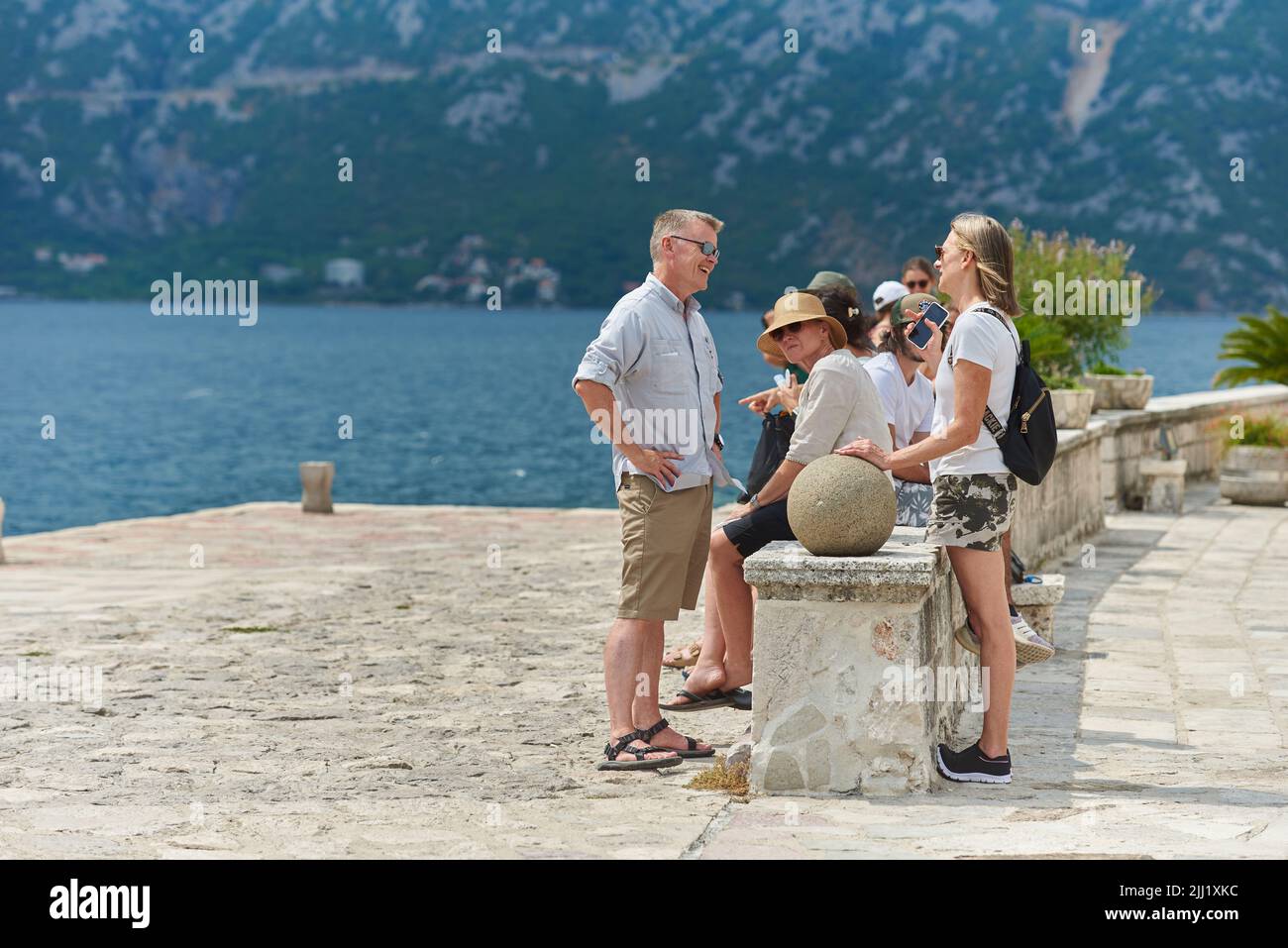 Man and woman tourists from Europe are talking on the seashore in the Balkan country. Stock Photo