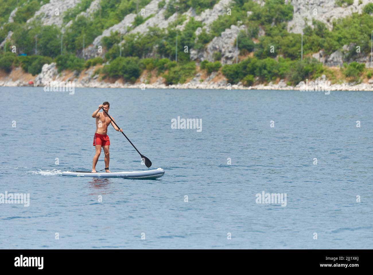 Young man swims on a sub board in the Adriatic Sea Stock Photo