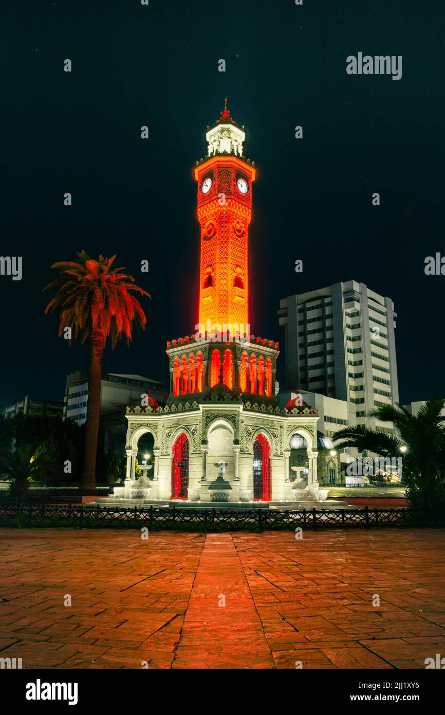 A vertical  shot of an exotic building at night with orange and red lights. Izmir watch tower. Stock Photo