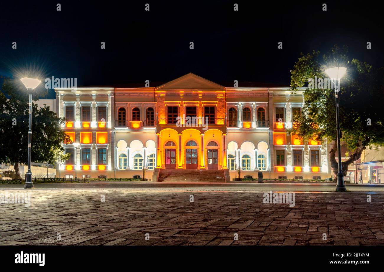A horizontal shot of an old building at night with orange and yellow lighting Stock Photo