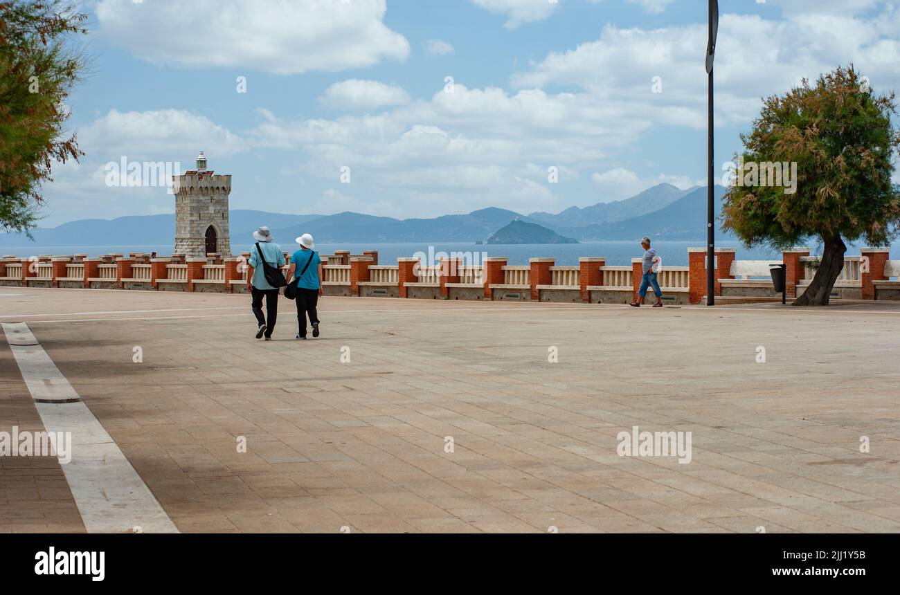People walking on the large terrace of Piazza Giovanni Bovio. Elba island in the background. Stock Photo