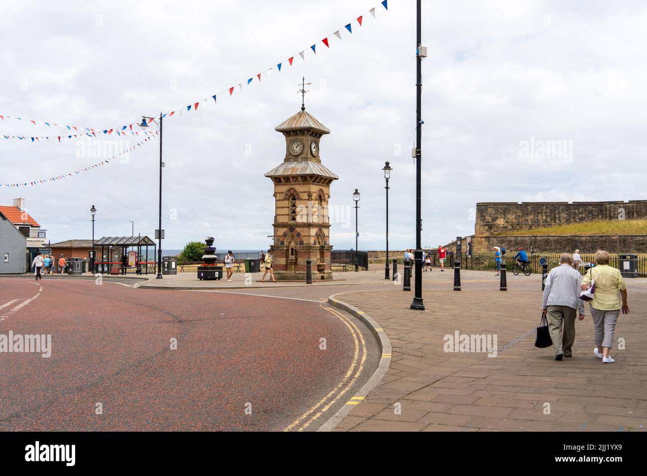 A view of the old clock tower on Front Street, Tynemouth Village, North Tyneside, UK, with tourists. Stock Photo