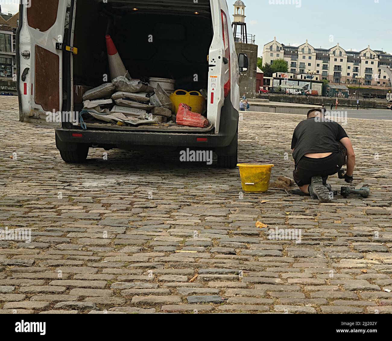 July 2022 - Man repairing the cobbles on the streets in Bristol ...