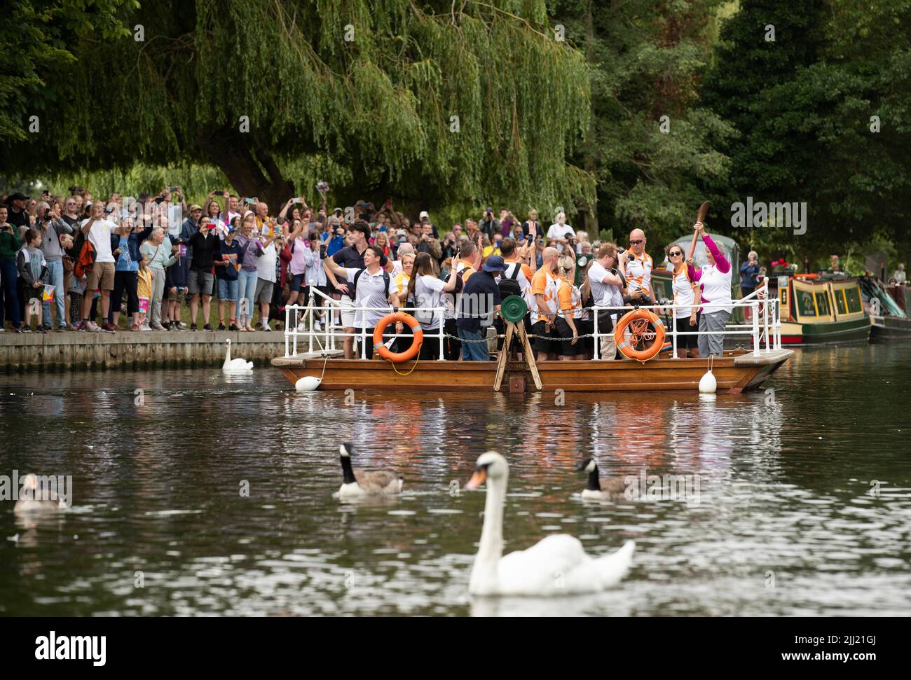 Stratford Upon Avon, UK. 22nd July, 2022. A Baton Bearer carries the Commonwealth Games Queen's Baton onboard a ferry as it crosses the river Avon in Stratford Upon Avon Warwickshire Credit: Chris Radburn/Alamy Live News Stock Photo
