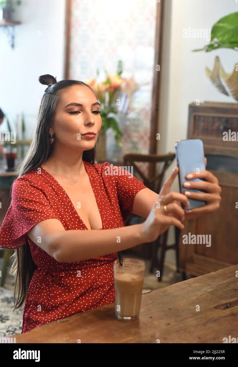 Young woman taking selfie in a coffee shop Stock Photo
