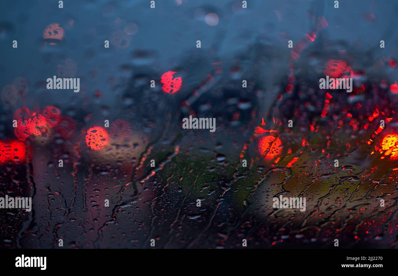 Light of the traffic and car on a rainy night through the windshield ...