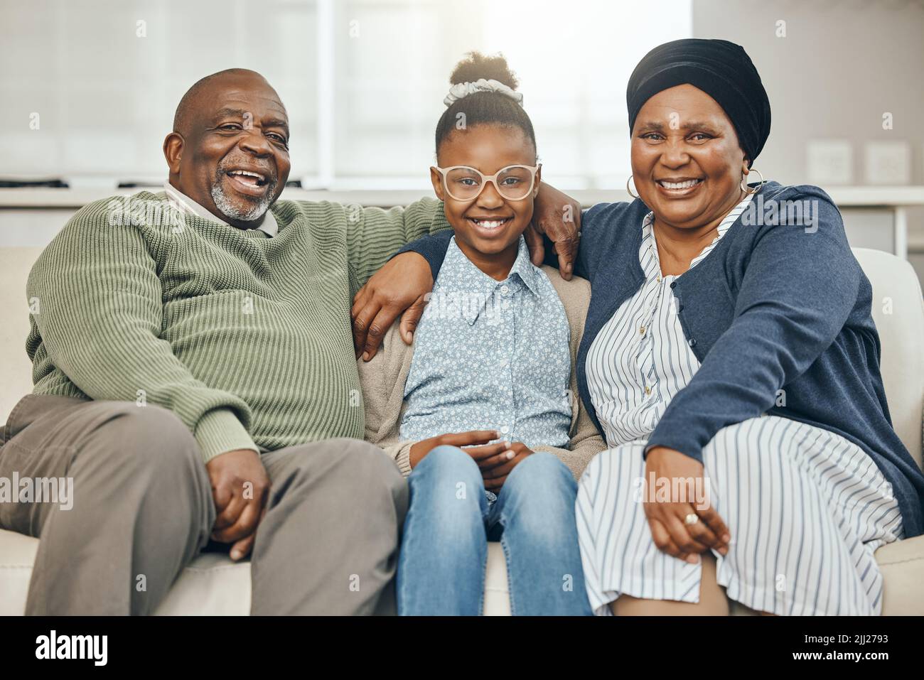 Passing on wisdom. two grandparents bonding with their grandchild on a sofa at home. Stock Photo