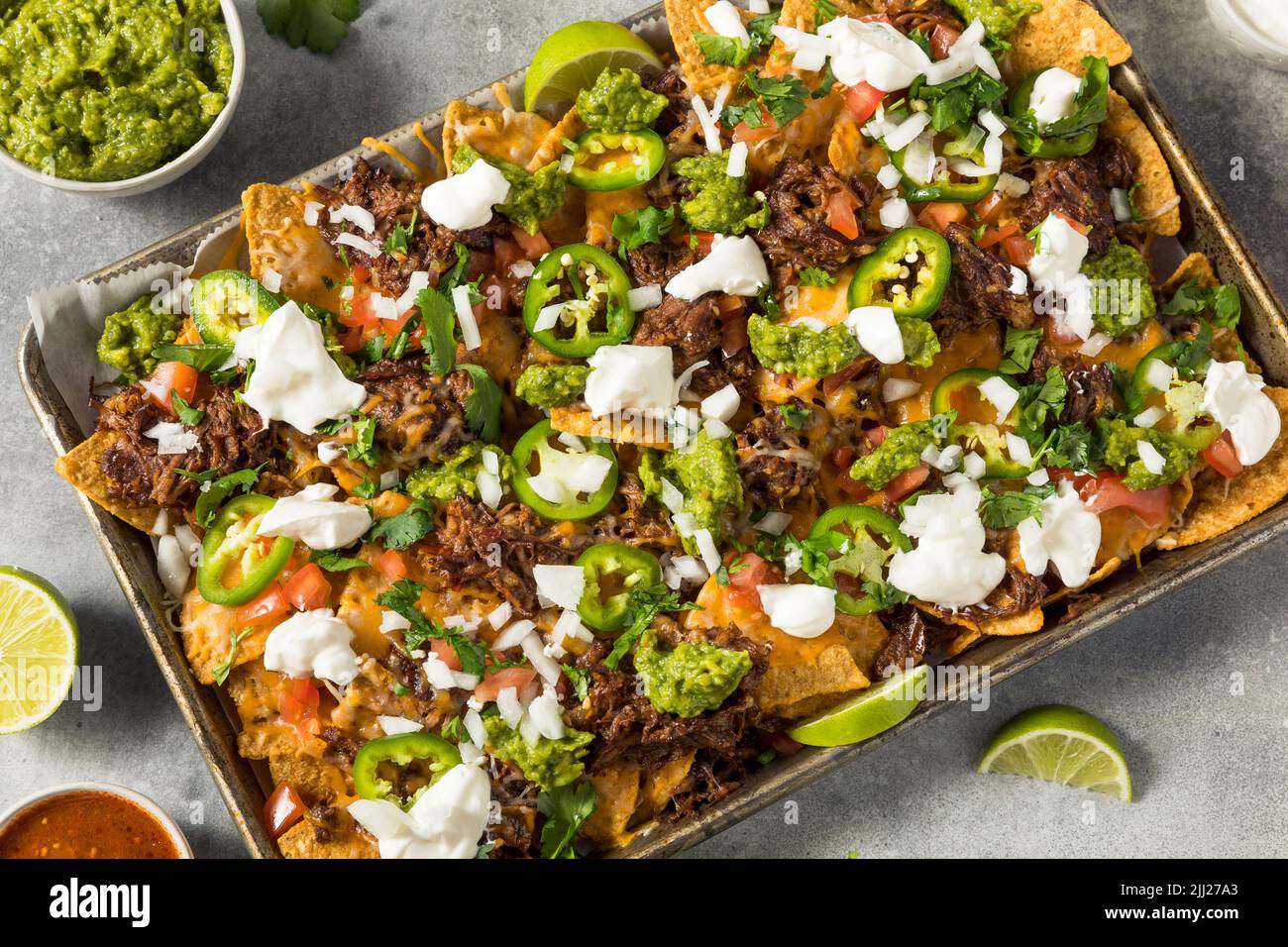 Homemade Mexican Shredded Beef Nachos with Gaucamole and Sour Cream Stock Photo